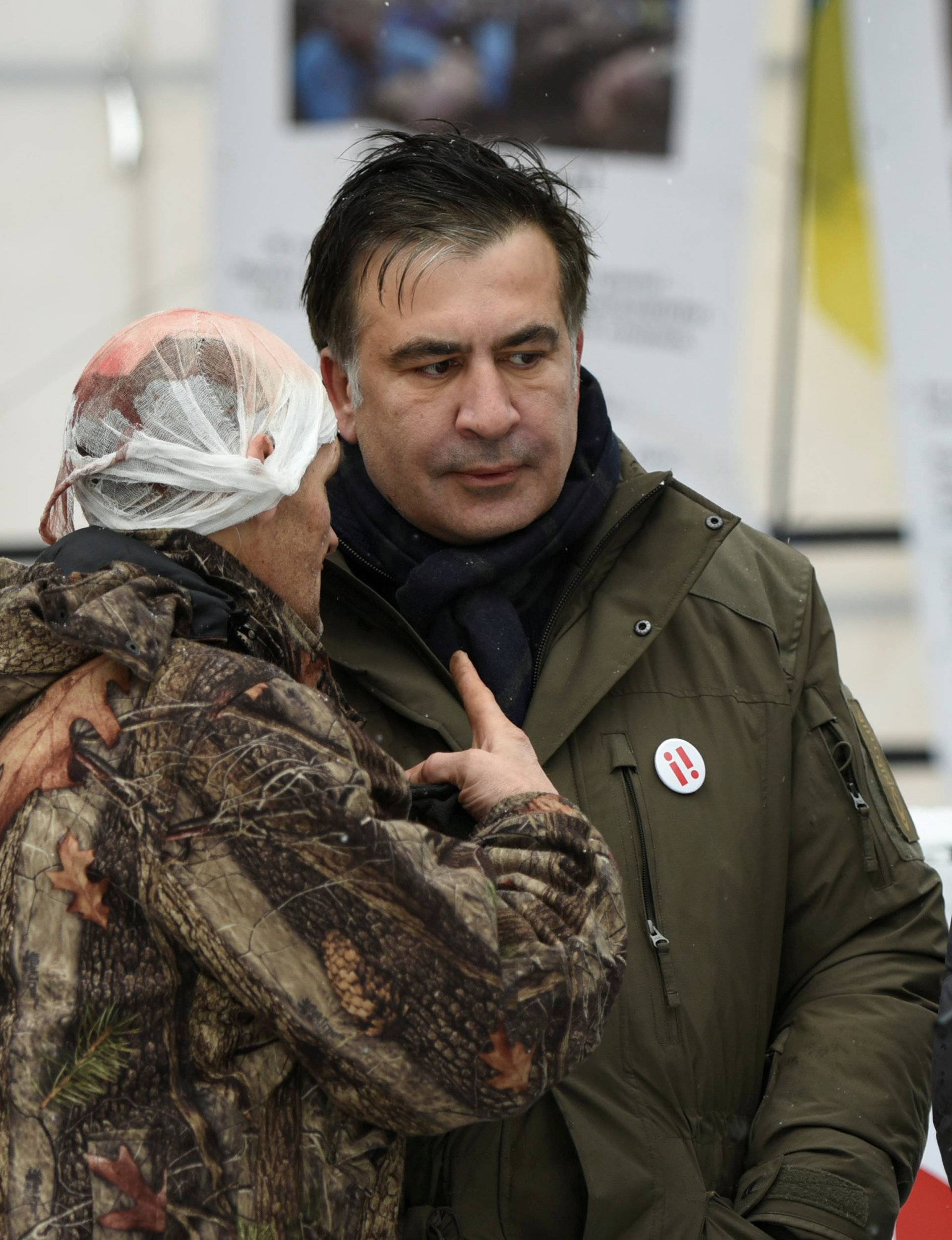 Former Georgian President Mikheil Saakashvili talks to his supporters, who say they were injured in clashes with the police, in front of the Parliament building in Kiev