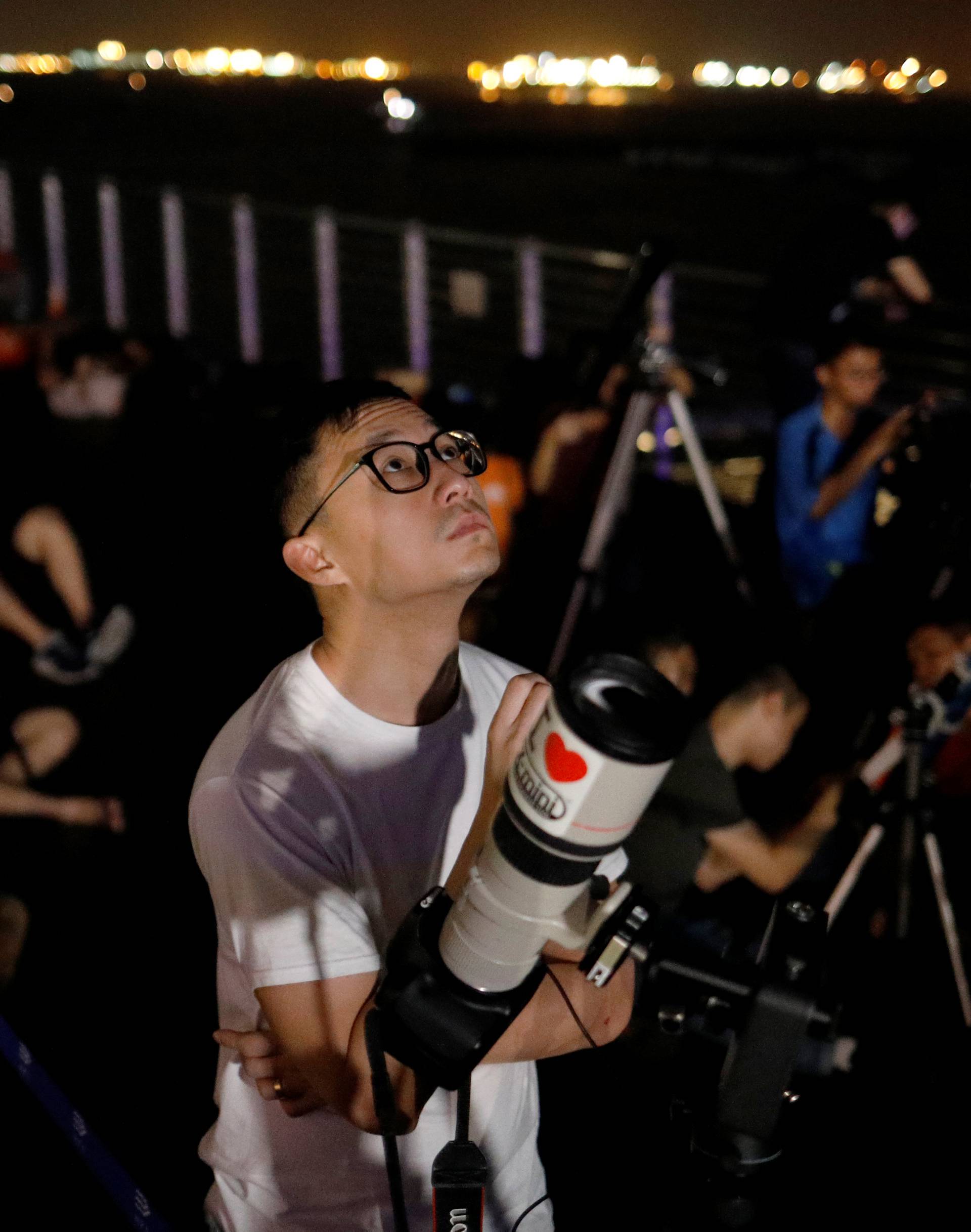 Astronomy enthusiasts wait to see the lunar eclipse of a blood moon at Marina South Pier in Singapore