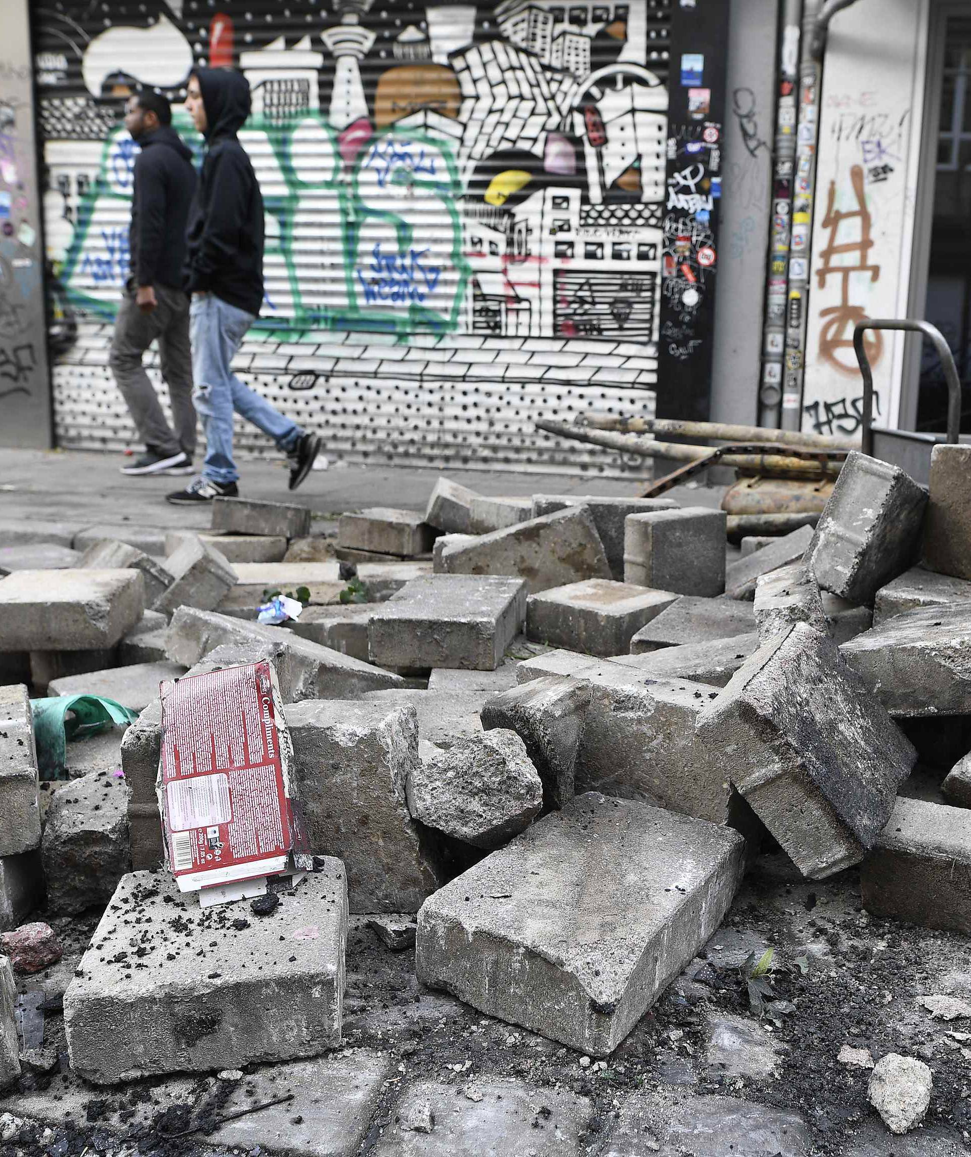 People walk on a street with damaged pavement after demonstrations at the G20 summit in Hamburg