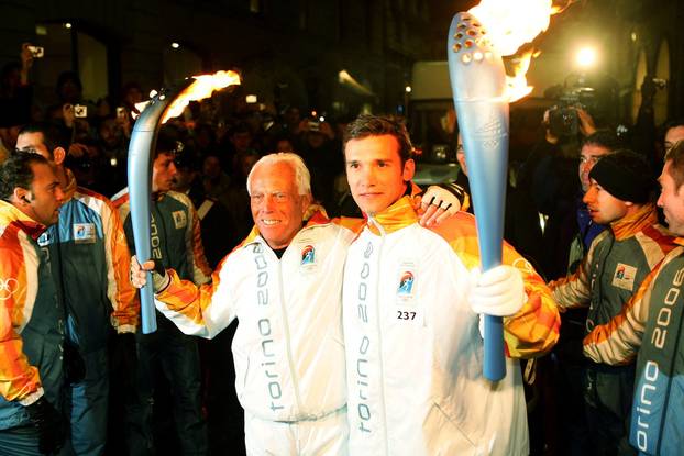 FILE PHOTO: AC Milan's Shevchenko of Ukraine and Italian fashion designer Armani exchange the Olympic flame in Milan