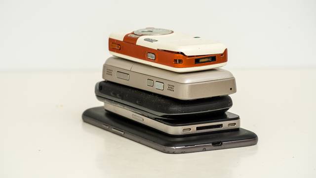 smartphones (used and broken) on white table