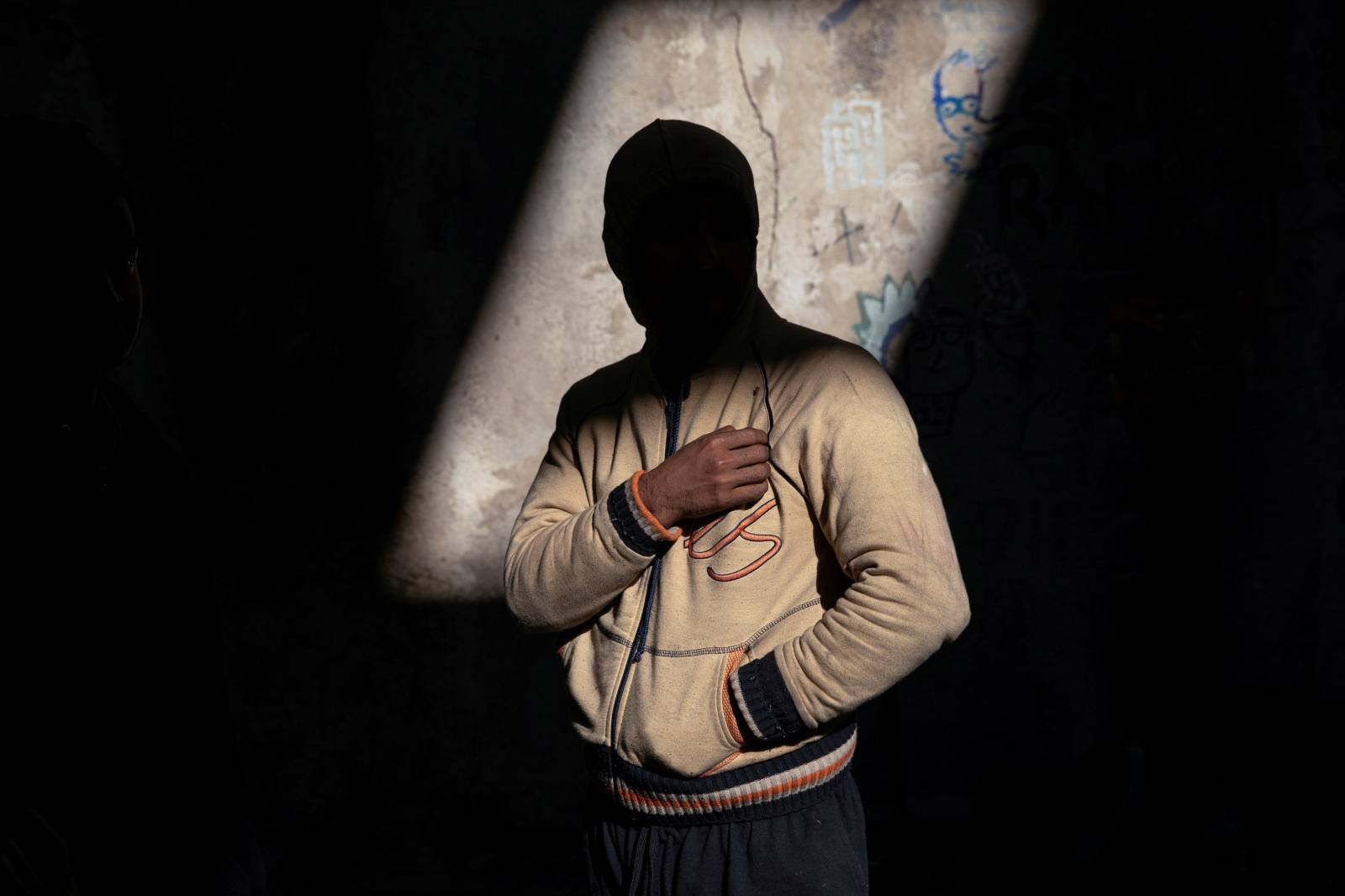 A migrant from Bangladesh stands inside an old abandoned factory near Velika Kladusa