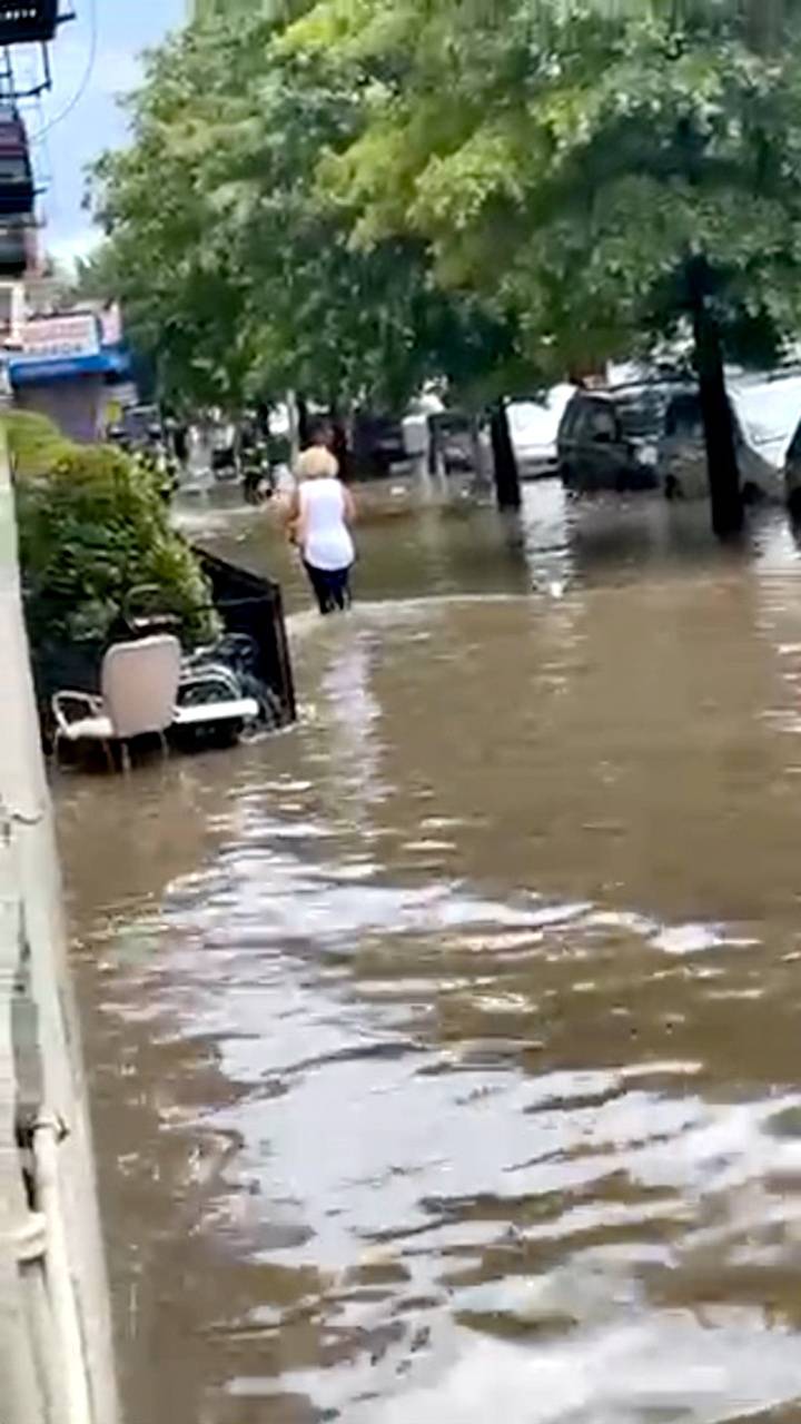 A women wades through a flooded street in New York