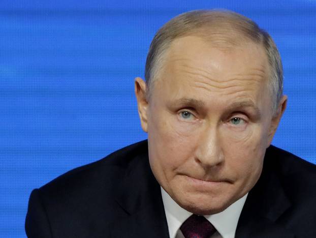 Russian President Putin listens during annual news conference in Moscow