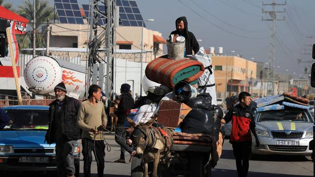 Palestinians flee their houses after they were ordered by the Israeli army to evacuate the area in Bureij