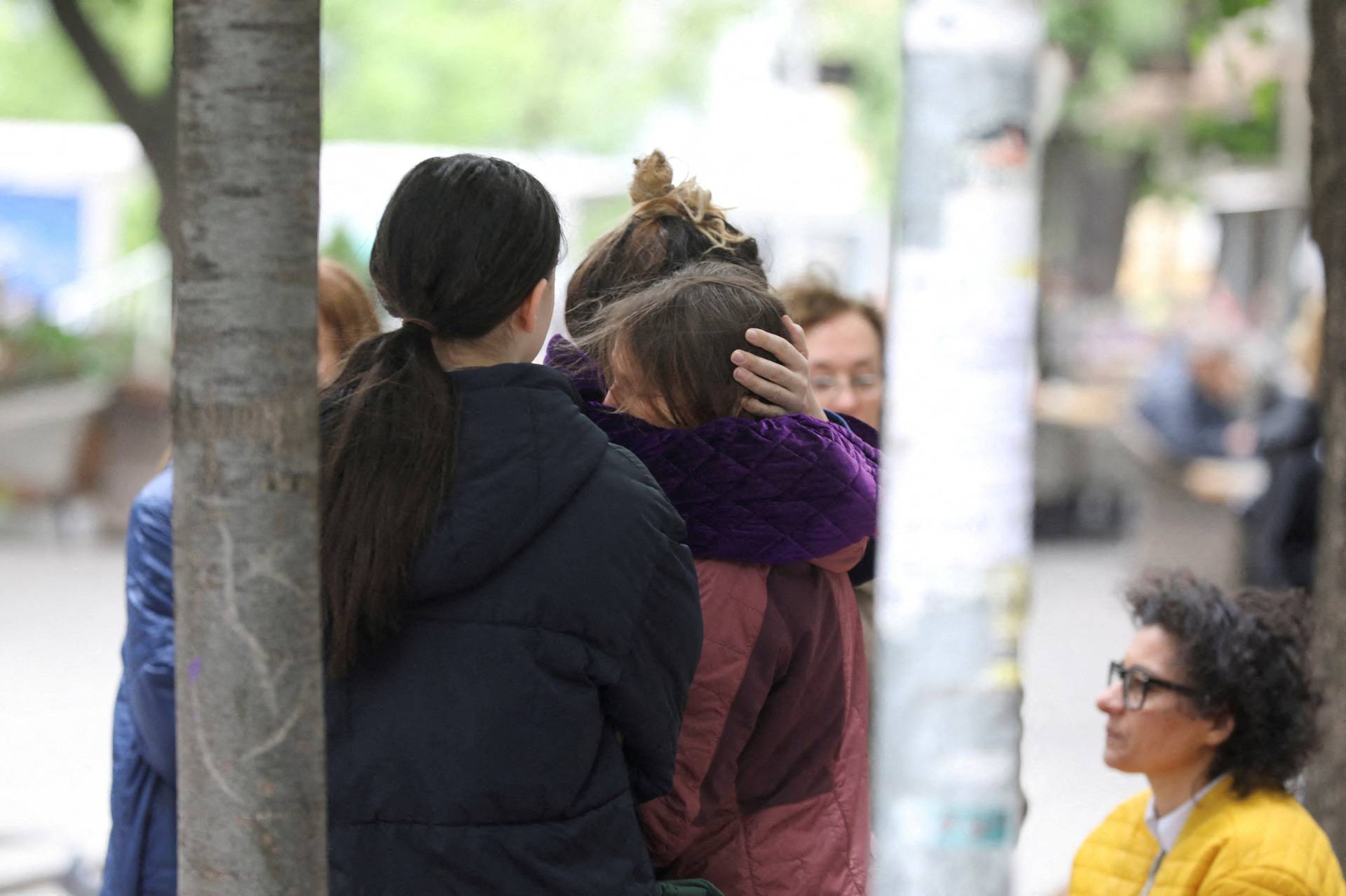 People react after a 14-year-old boy opened fire on other students and security guards at a school in downtown Belgrade