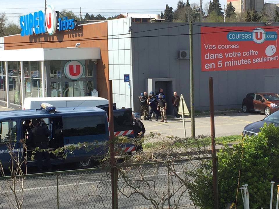 Police are seen at the scene of a hostage situation in a supermarket in Trebes