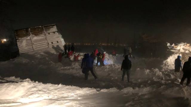 Rescuers take part in a search operation after an avalanche hit a ski resort in Norilsk