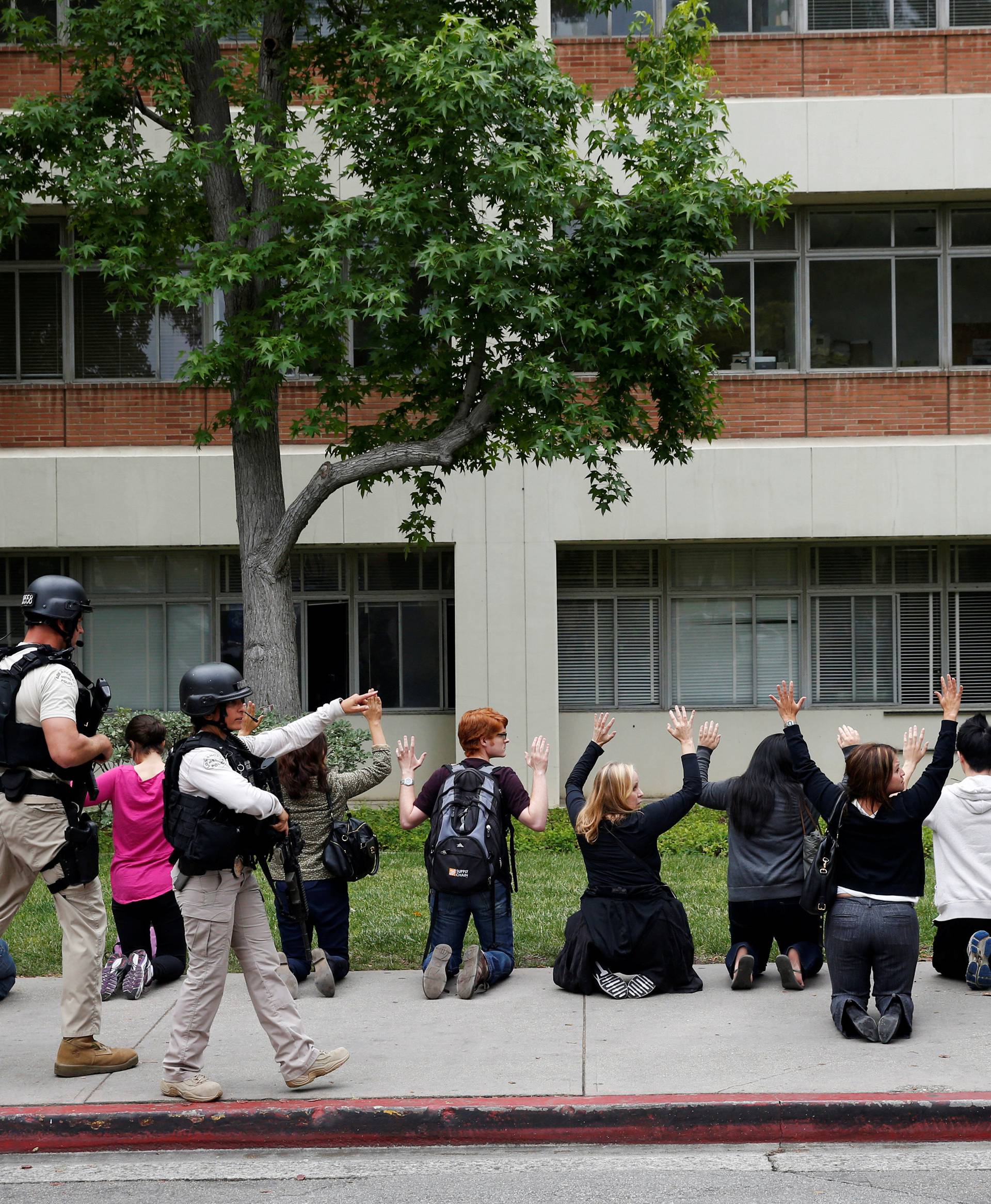 Police officers conduct a search on people at the UCLA campus after it was placed on lockdown following reports of a shooter that left 2 people dead in Los Angeles, California