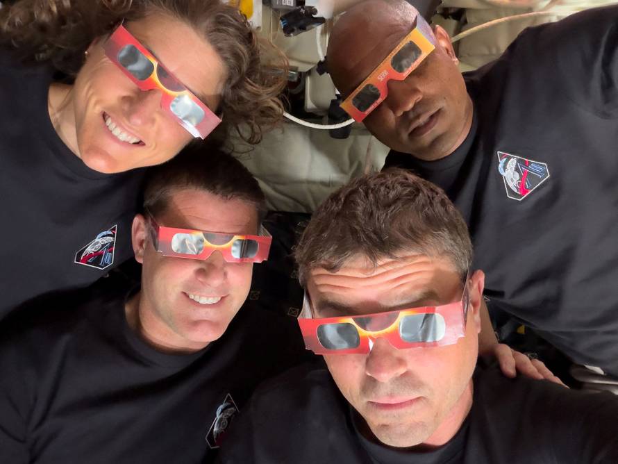 The Artemis II crew of NASA astronauts Christina Koch, Reid Wiseman, Victor Glover and Canadian Space Agency astronaut Jeremy Hansen pose with their eclipse glasses