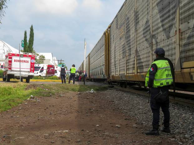 Authorities work at the scene where a passenger bus was struck by a train, in Atlacomulco