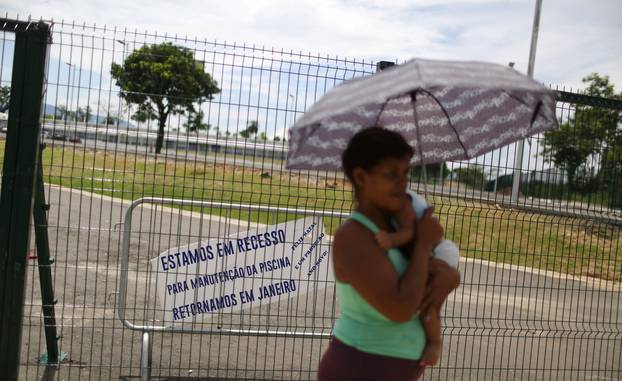 A woman carries a baby in front of the Deodoro Sports Complex, which was used for the Rio 2016 Olympic Games, in Rio de Janeiro
