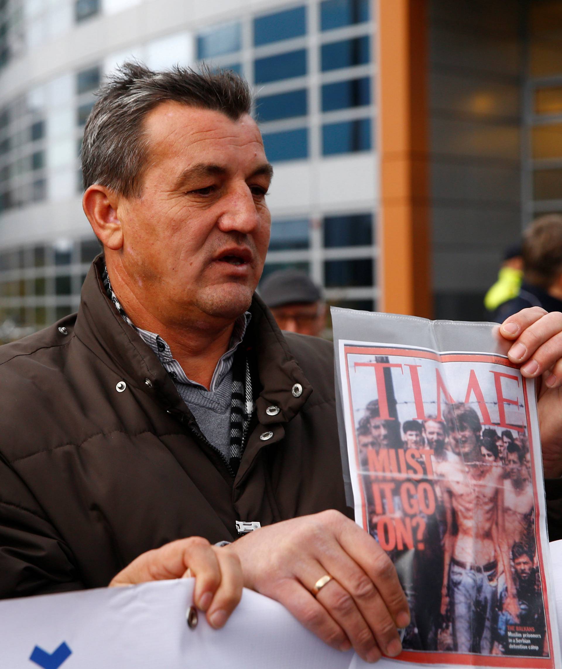 Fikret Alic, one of the survivors of concentration camps shows his photo on the cover of Time before the trial of former Bosnian Serb military commander Ratko Mladic before a court at the International Criminal Tribunal for the former Yugoslavia (ICTY) in