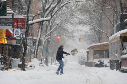 A person shovels snow in the Greenwich Village neighborhood in New York