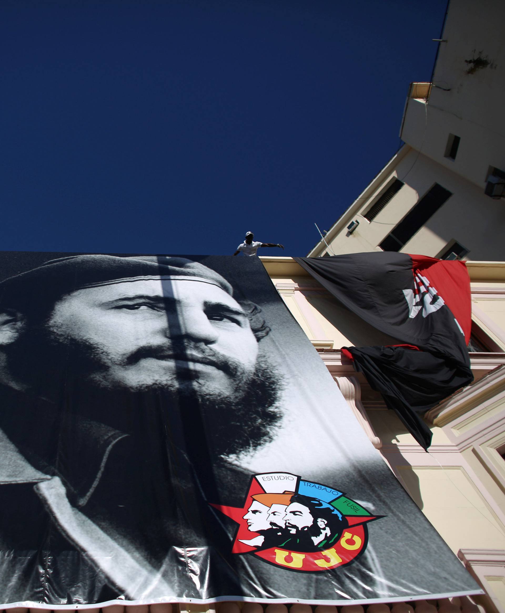 A man hangs a photograph of Cuba's former President Fidel Castro in Havana, Cuba