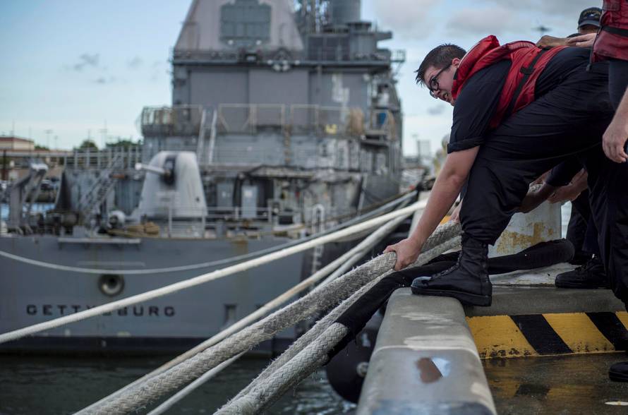 A U.S. Navy handout photo of a sailor heaving line in preparation ahead of Hurricane Florence in Norfolk