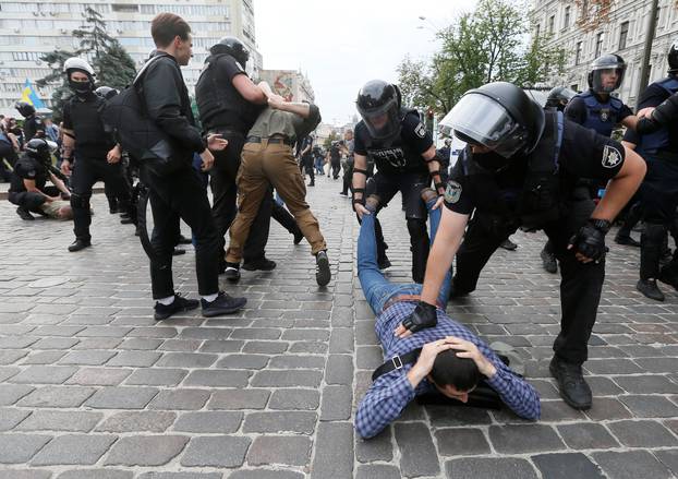 Riot police officers detain anti-LGBT protesters during the Equality March in Kiev