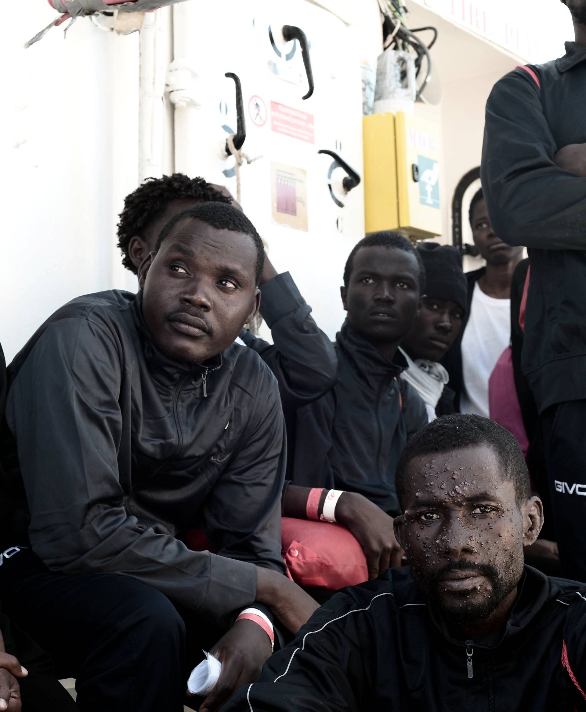 Migrants wait to disembark from the Aquarius rescue ship after arriving to port in Valencia