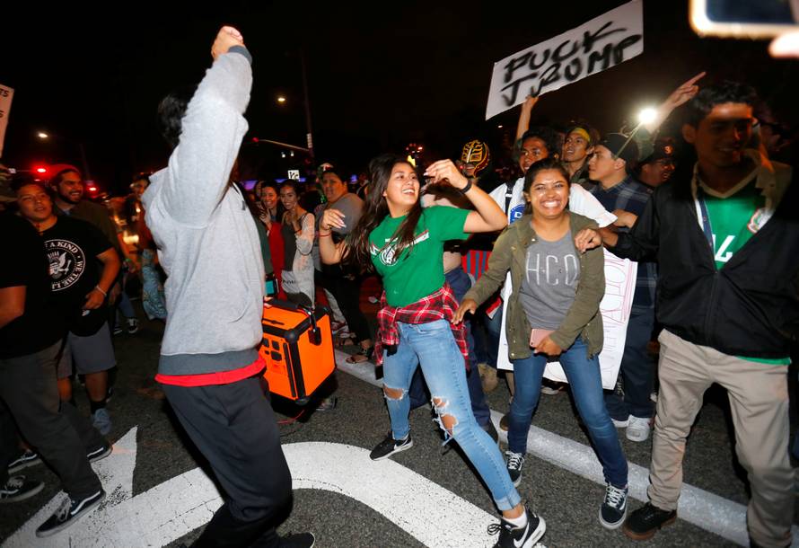 Demonstrators dance in the street outside Republican U.S. presidential candidate Donald Trump's campaign rally in Costa Mesa