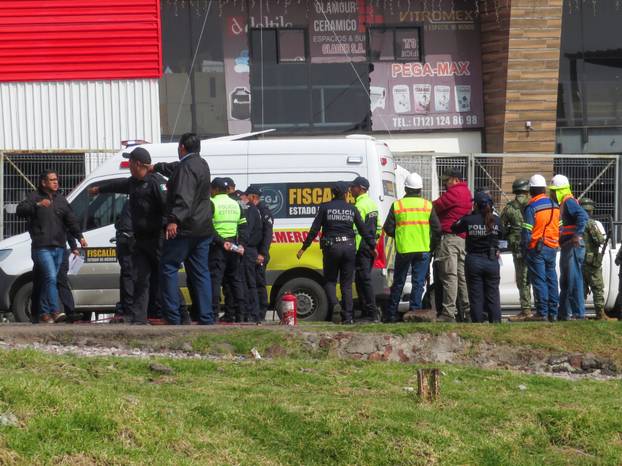 Authorities work at the scene where a passenger bus was struck by a train, in Atlacomulco