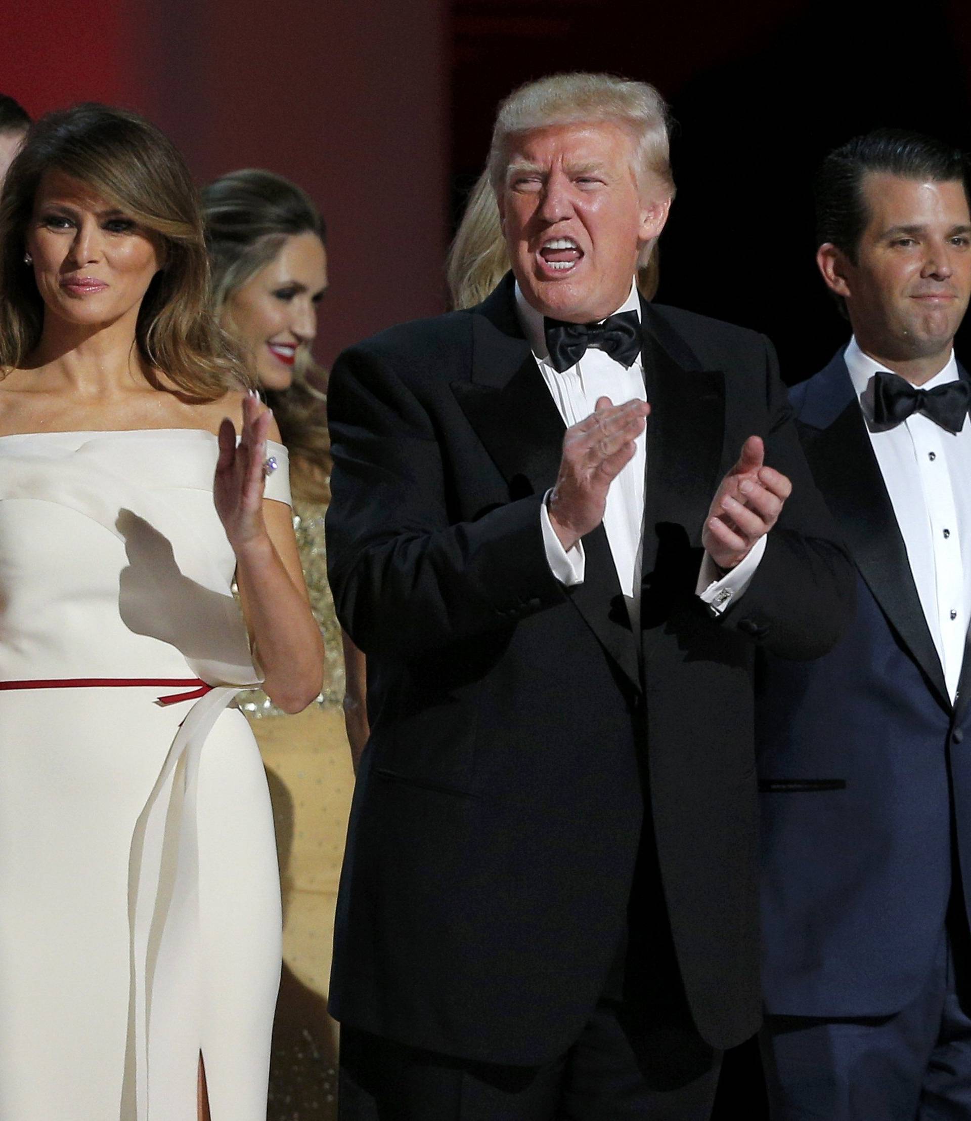 U.S. President Donald Trump applauds while flanked by his wife Melania and his son Donald Jr. at his "Liberty" Inaugural Ball in Washington