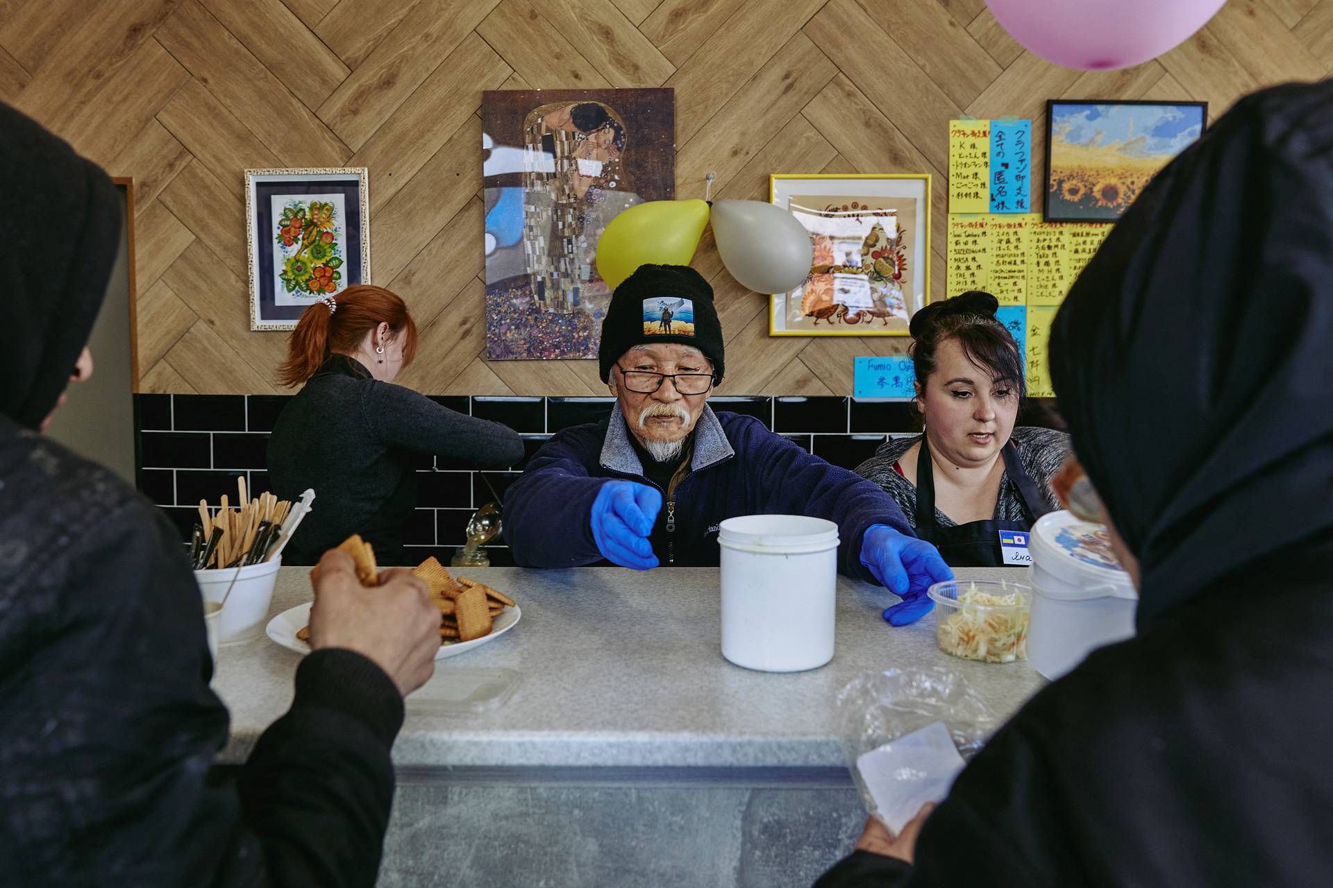 Humanitarian volunteer  Fuminori Tsuchiko from Japan passes free food to people at his cafe in Kharkiv