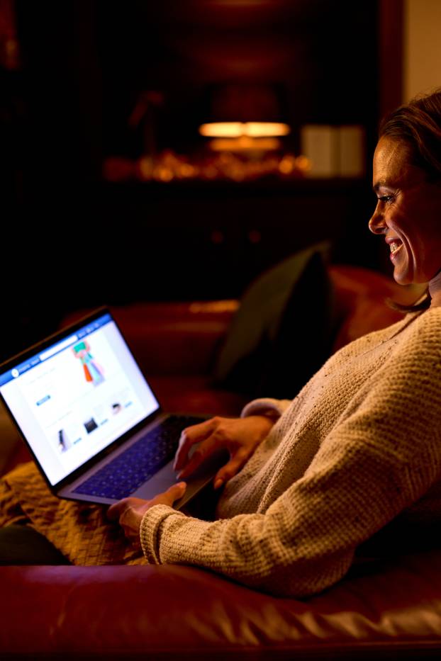 Side,View,Of,Woman,At,Home,Sitting,In,Lounge,At