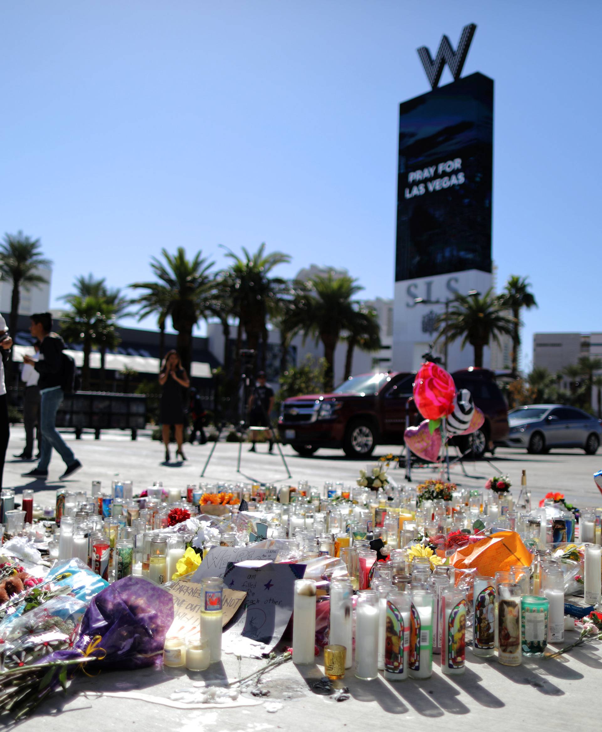 A woman looks at a makeshift memorial on the Las Vegas Strip for victims of the Route 91 music festival mass shooting next to the Mandalay Bay Resort and Casino in Las Vegas