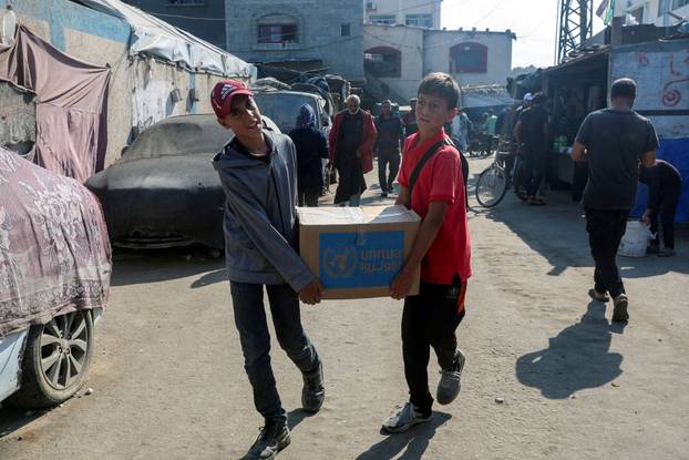 FILE PHOTO: Palestinians receive aid from UNRWA in Deir Al-Balah, central Gaza Strip
