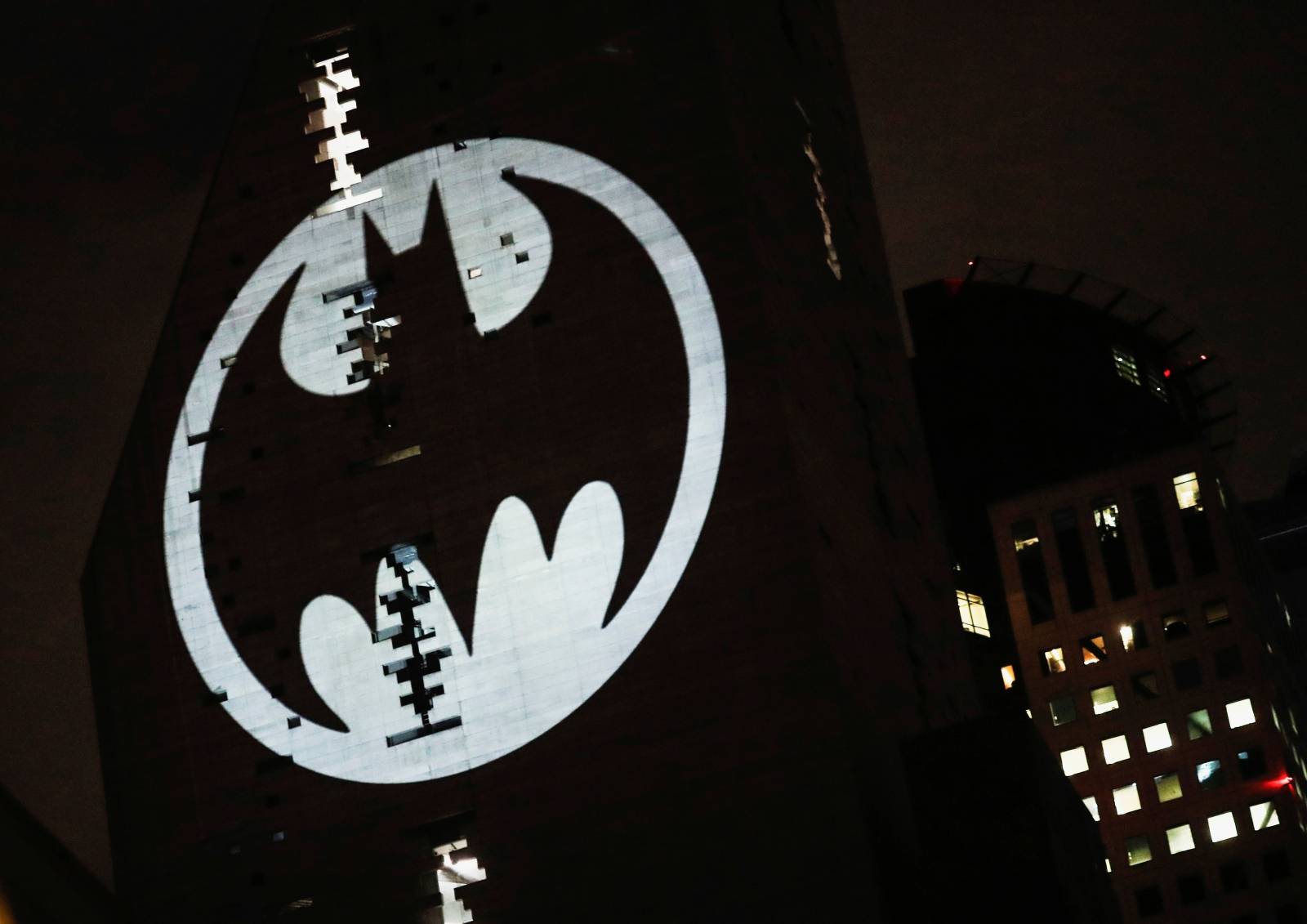 A Bat-Signal is projected onto a building at night as Batman fans celebrate the 80th anniversary of the first appearance of the DC Comics superhero, in Mexico City