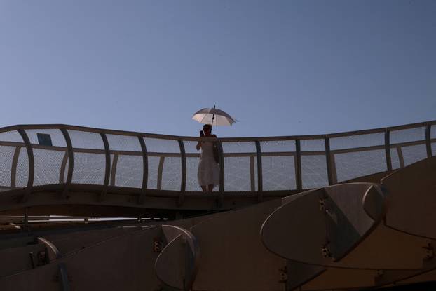 A tourist walks with an umbrella on Las Setas during a heatwave in Seville