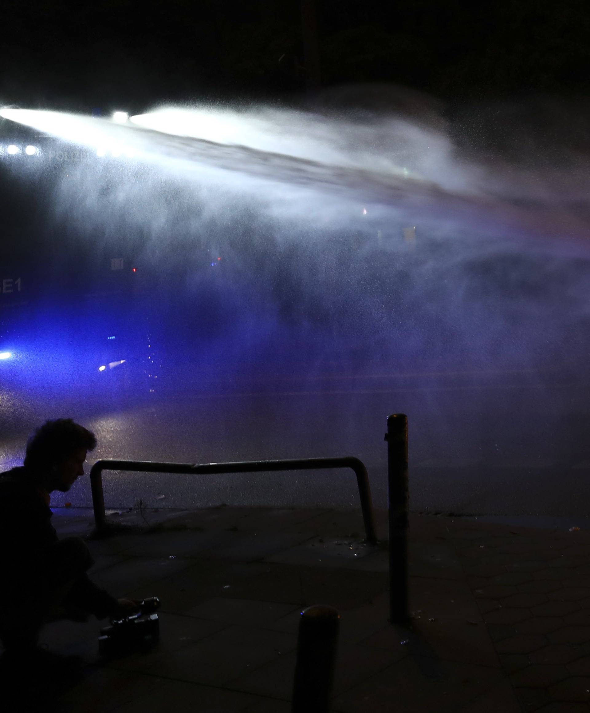 Police uses a water cannon to extinguish a burning barricade following the G20 summit in Hamburg