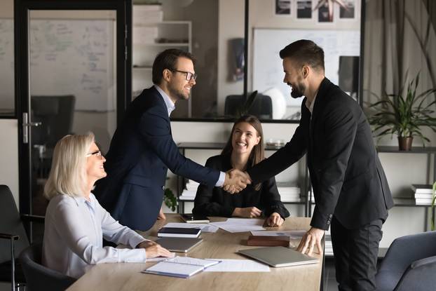 Two,Happy,Confident,Business,Partners,Men,Shaking,Hands,Over,Large