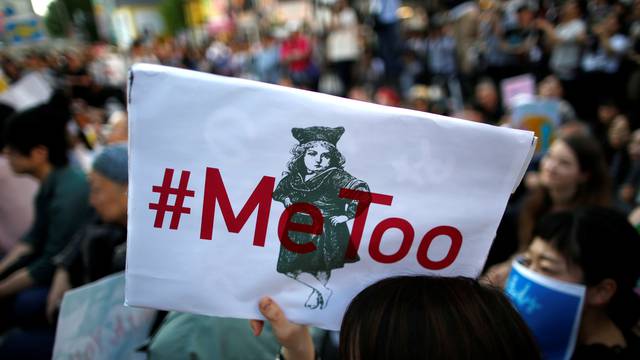 A protester raises a placard reading "#MeToo" during a rally against harassment in Tokyo