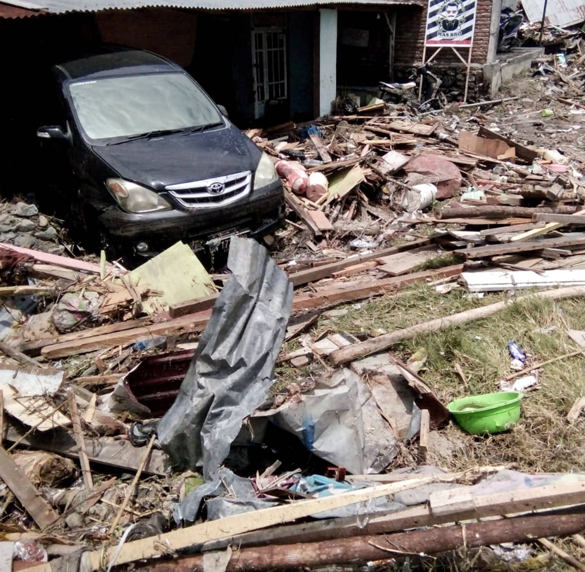 Damaged car as seen at broken house after earthquake hit in Palu