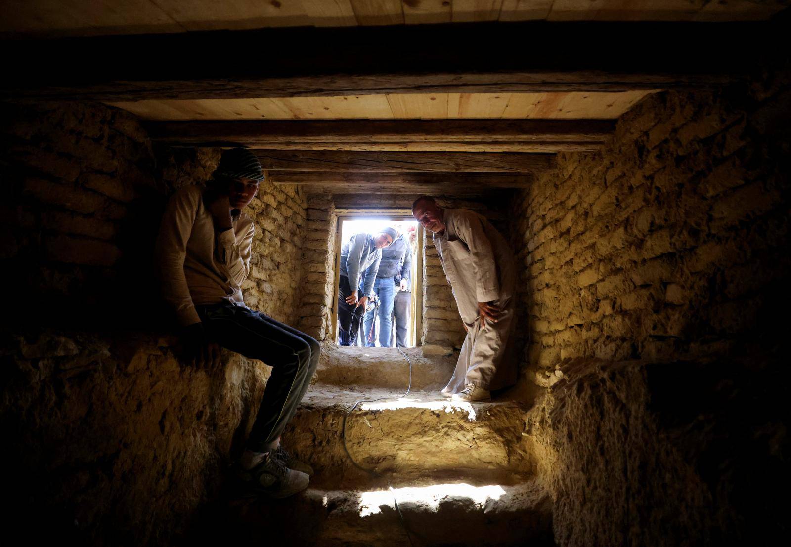 A man sits inside a tomb after the announcement of 4,300-year-old sealed tombs discovered in Egypt's Saqqara necropolis, in Giza