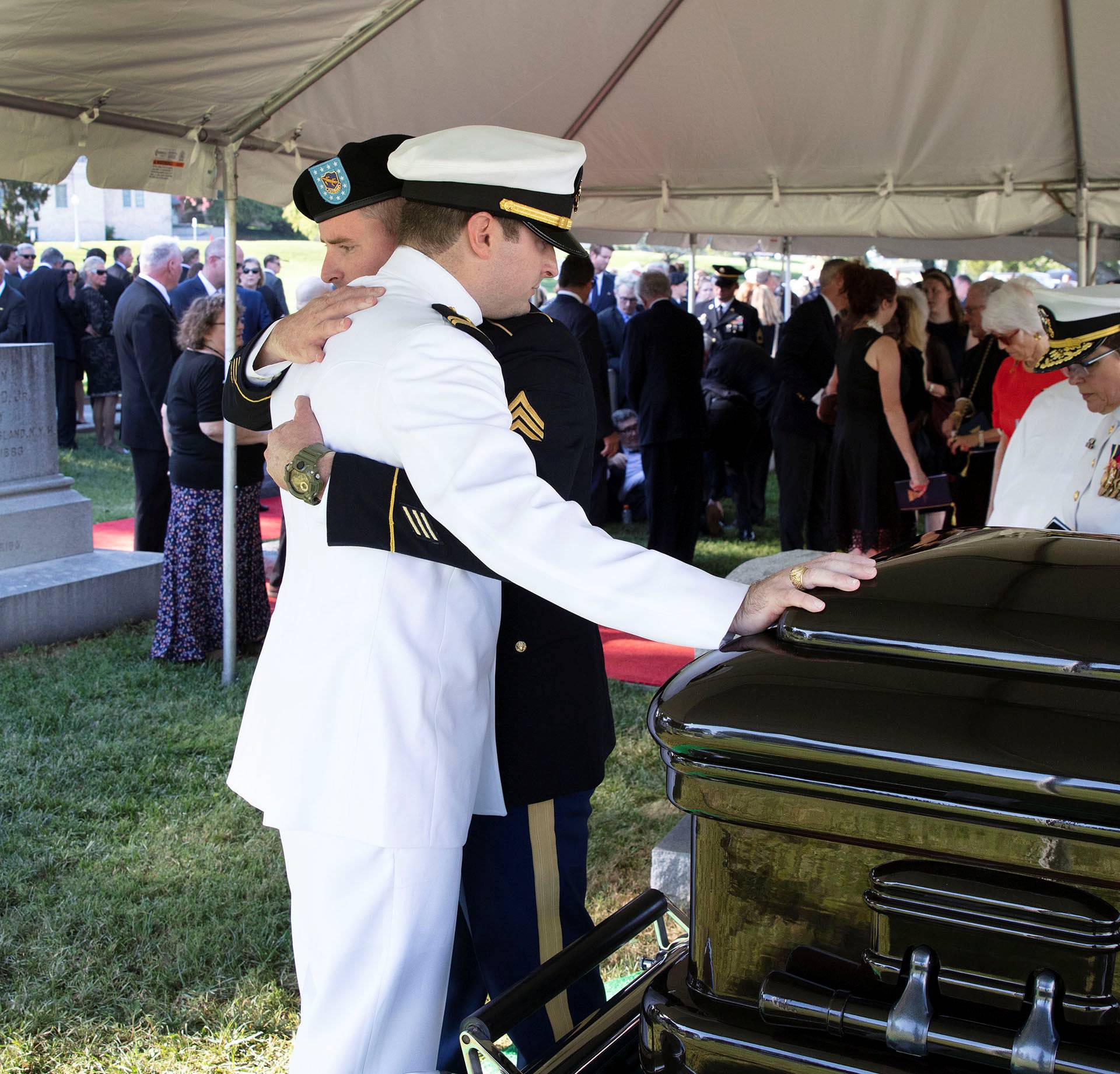 Jimmy McCain hugs his brother Jack during a burial service for McCain in Annapolis