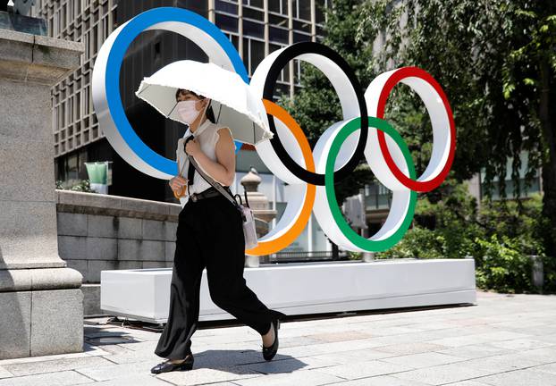 Woman walks in front of Olympic rings monument ahead of Tokyo 2020 Olympic Games in Tokyo