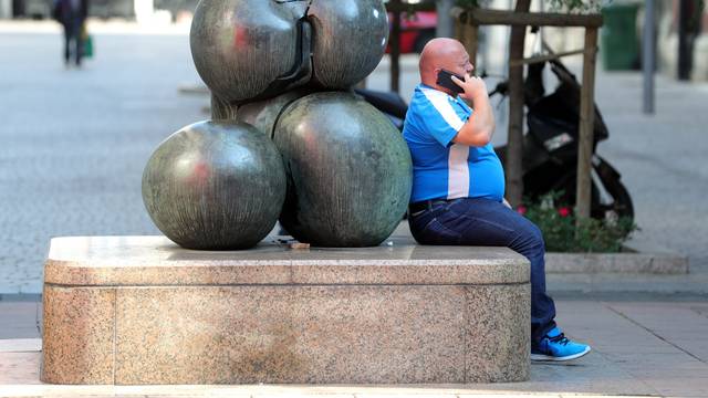Zagreb: Muškarac razgovara na mobitel pored skulpture Veliki torzo