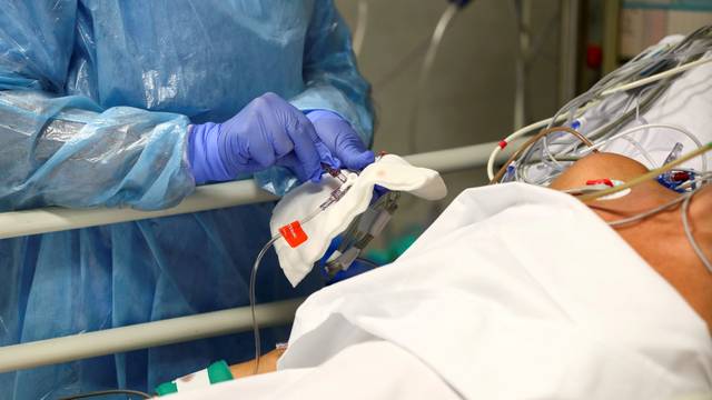 FILE PHOTO: A medical worker takes care of a patient infected with COVID-19 at the intensive care unit (ICU) of the Infanta Sofia University hospital in Spain