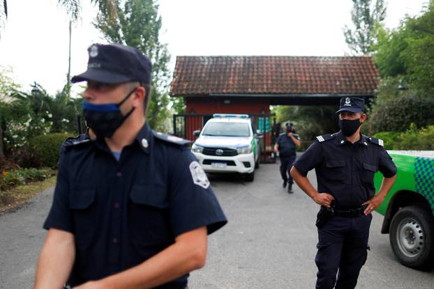 Police officers stand guard outside the house where Diego Maradona was recovering from surgery, in Tigre