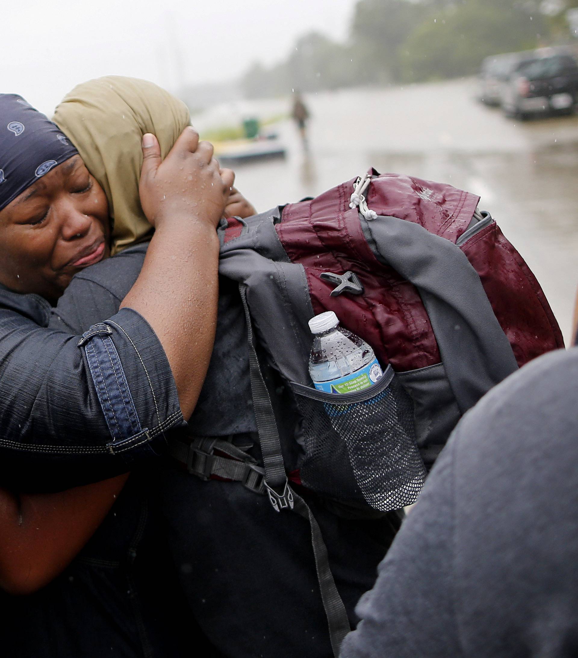 Residents embrace after being rescued from the flood waters of tropical storm Harvey in east Houston