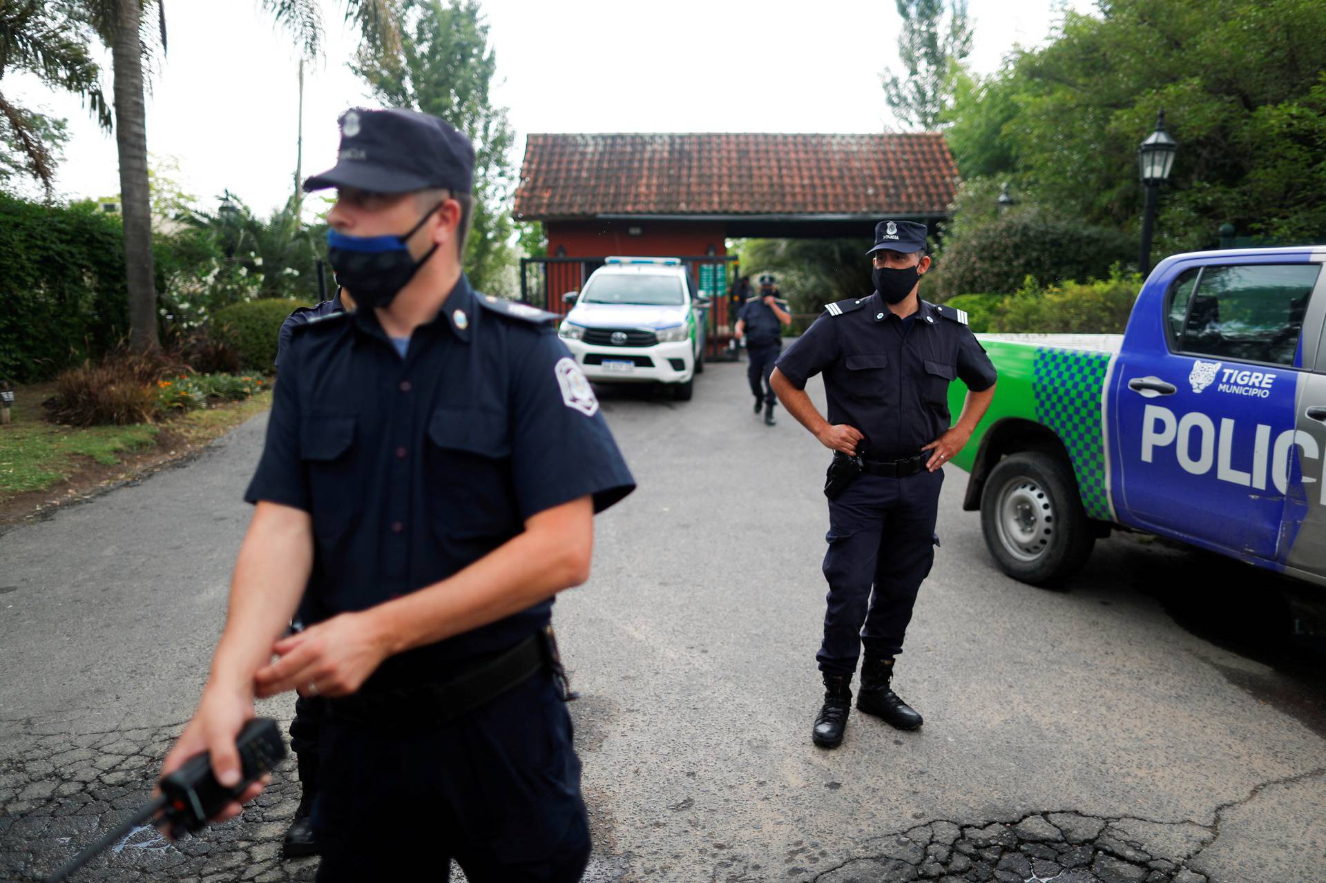Police officers stand guard outside the house where Diego Maradona was recovering from surgery, in Tigre