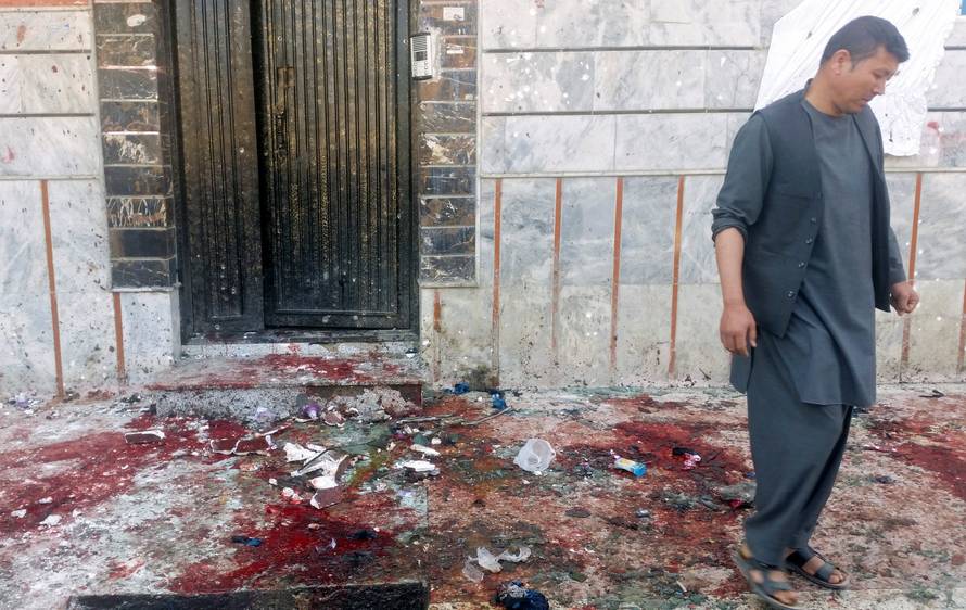 An Afghan man inspects the site of a blast in Kabul