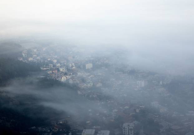 Buildings are seen as fog blankets the valley of city Skopje