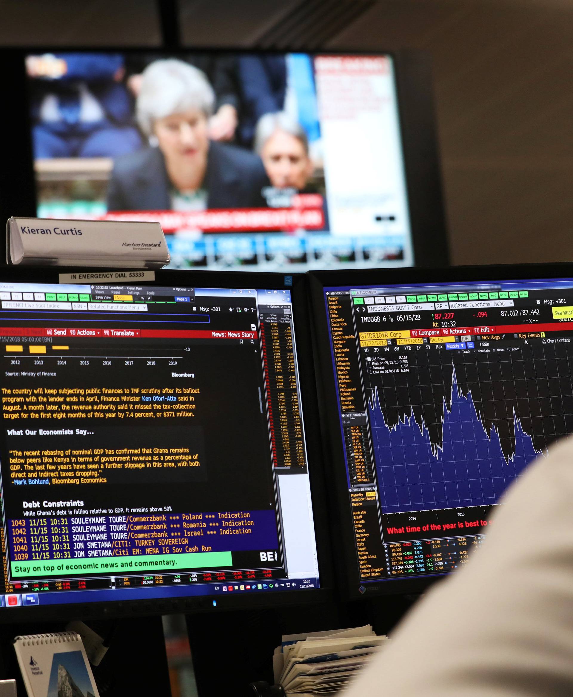 An investment manager, in the office of Aberdeen Standard Investments, watches Britain's Prime Minister, Theresa May, deliver a statement to the House of Commons, in London