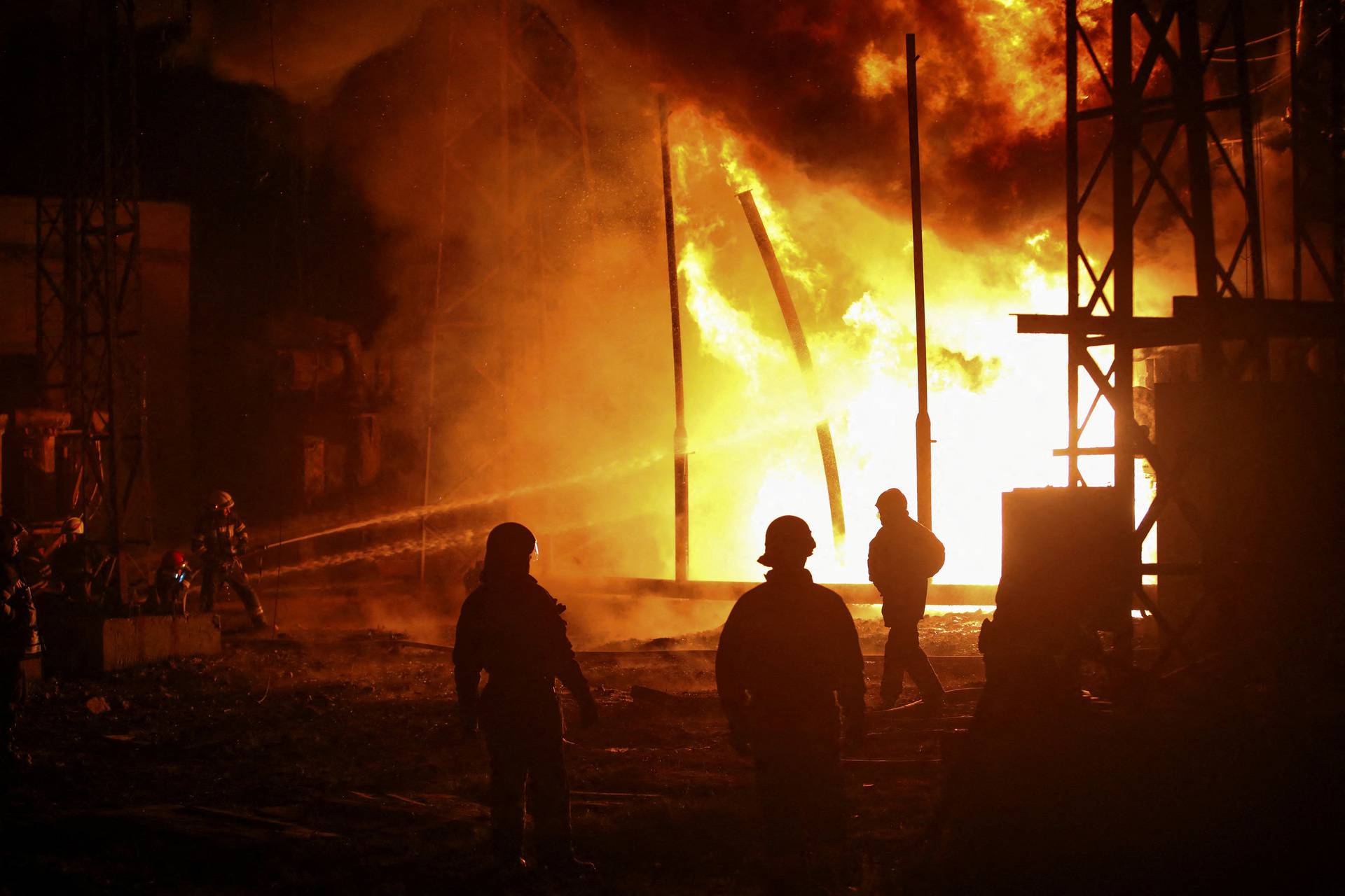 Firefighters work at a site of a thermal power plant damaged by a Russian missile strike in Kharkiv
