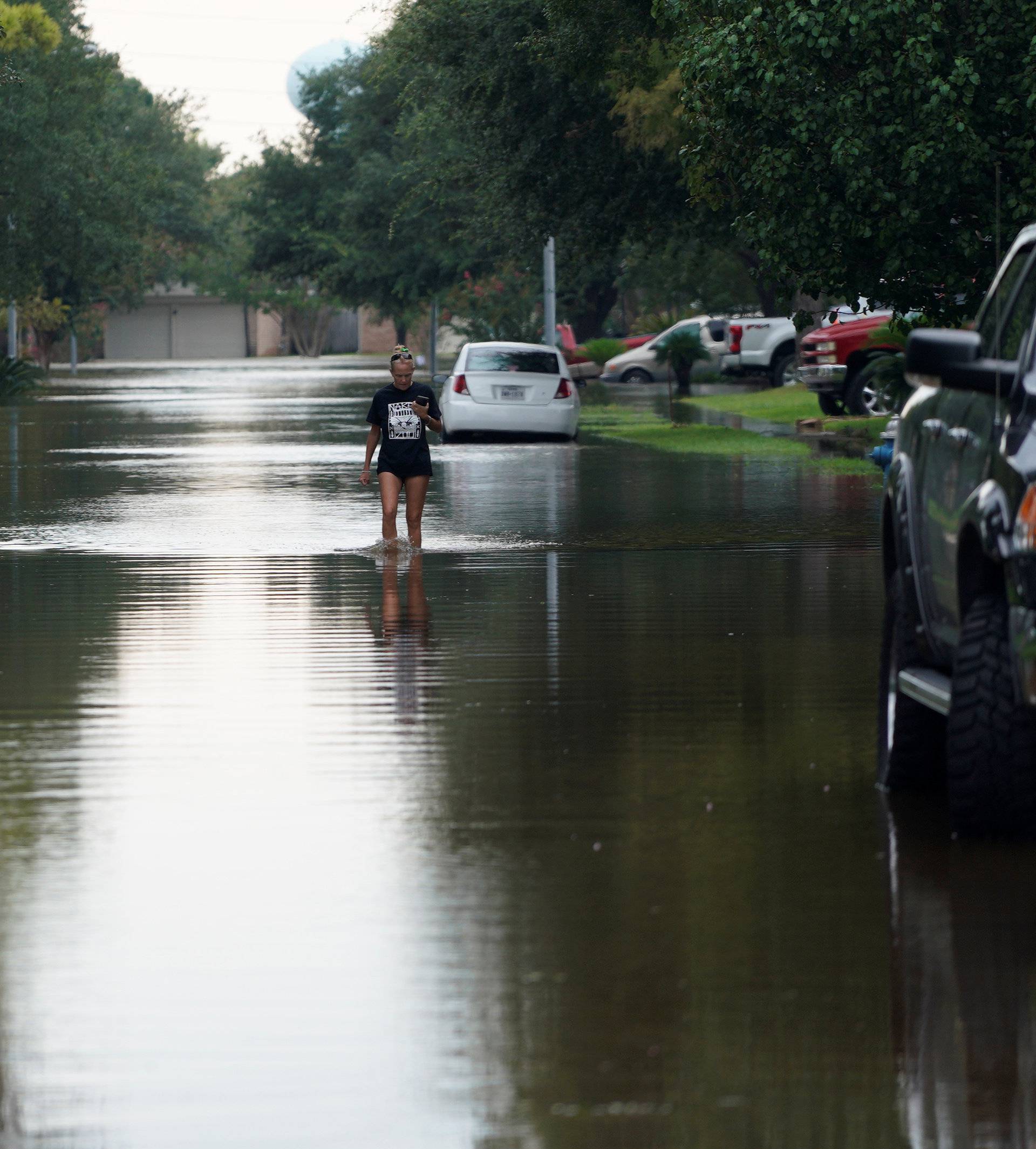 A woman walks out of Tropical Storm Harvey floodwaters in north western Houston