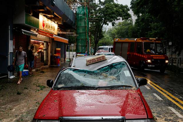 A taxi damaged by fallen trees is seen following Super Typhoon Saola in Hong Kong