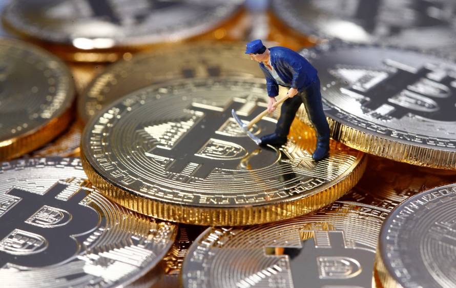 A small toy figure is seen on representations of the Bitcoin virtual currency in this illustration picture